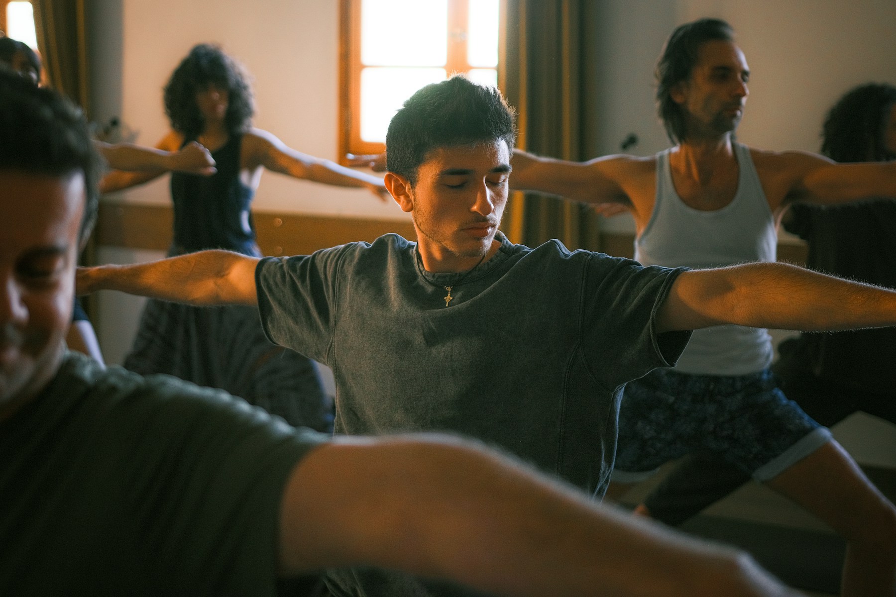 Students practicing yoga together in a sunlit studio